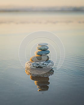 Pyramid of stones on the beach at sunset. Tranquil scene, relaxation, seaside vacation, meditation concept