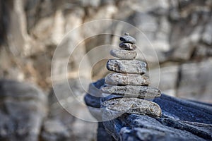 Pyramid of various stones on a background of rock