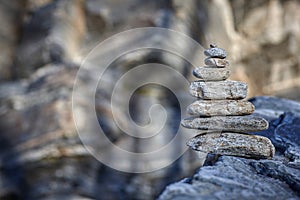 Pyramid of various stones on a background of rock