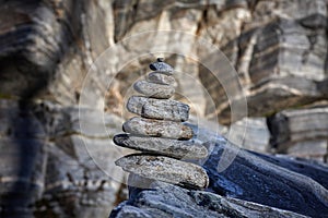 Pyramid of various stones on a background of rock