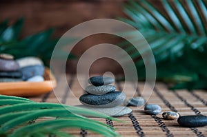 Pyramids of gray zen stones with green leaves and Buddha statue. Concept of harmony, balance and meditation, spa, massage, relax