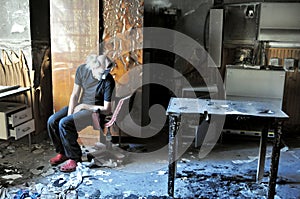 Pyromaniac man in a room with burnt objects, madness concept