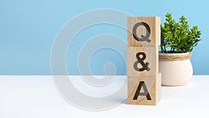Q AND A - acronym from wooden blocks with letters, questions and answers. concept on grey background. copy space
