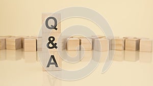 Q and A - acronym from wooden blocks with letters, questions and answers concept on yellow background. copy space