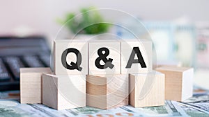 Q and A concept with wooden blocks and coins on table, business concept photo