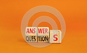 Q and A questions and answers symbol. Turned wooden cubes and changed the word questions to answers. Beautiful orange background,
