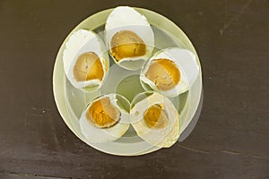 q salted duck egg telur asinserved in white plate isolated on wood background