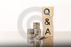 q and a - text on wooden cubes on white background with coins