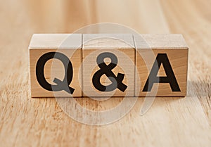 QA or Q concept in eco questions. QnA acronym on wooden cubes on wood