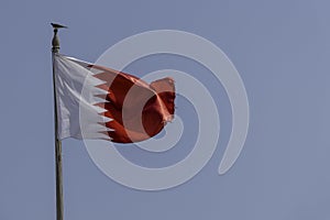 Qatar, Doha, flag of Qatar on blue sky background photo