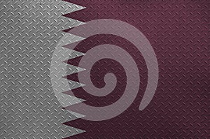 Qatar flag depicted in paint colors on old brushed metal plate or wall closeup. Textured banner on rough background
