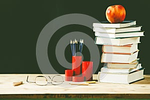 Qback to school concept pile of books against chalkboard