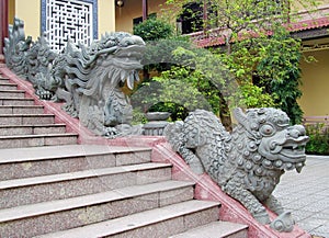 Qilin small dragon statue at temple stairs photo