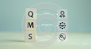 QMS, Quality management system concept. Formalized system for achieving quality policies and objectives. ISO 9001 standard. Wood photo