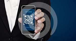 QR code scanning payment and verification. Businessman holding mobile smart phone scan QR code on screen photo