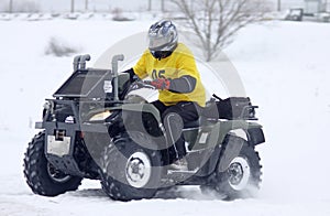 The quad bike driver rides over snow track