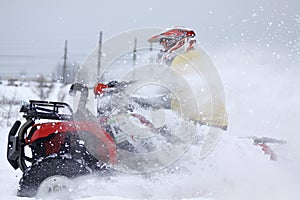 The quad bike's driver rides over snow track