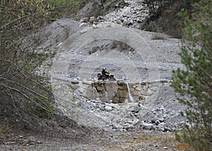 quad bike wades the mountain stream