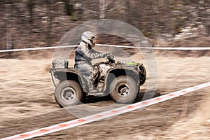 Quad competition. Man driving quad during the race among mud.