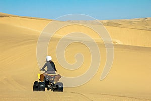 Quad driving people - happy biker in sand desert.