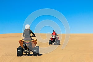 Quad driving people - two happy bikers in sand desert dunes, Africa, Namibia, Namib, Walvis Bay, Swakopmund.