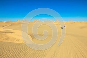 Quad driving people - two happy bikers in sand desert dunes, Africa, Namibia, Namib, Walvis Bay, Swakopmund.