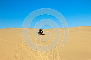 Quad driving people - two happy bikers in sand desert dunes, Africa, Namibia, Namib, Walvis Bay, Swakopmund.