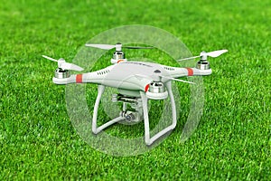 Quadcopter drone with 4K video camera on green grass