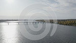 A quadcopter flies over a bridge over a river in Old Russia, cars drive across the bridge