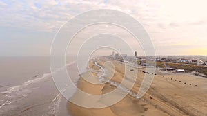 Quadcopter flight over the Zandvoort beach in the Netherlands. Morning sunrise over the city