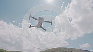 Quadcopter flying on background of mountains and sky. Action. Professional quadcopter for shooting while traveling