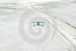 Quadcopter shadow on white sand, drone on sand