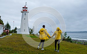 Quadra Island old historical lighthouse Cape Mudge Vancouver Island, couple in yellow rain coat
