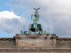 The Quadriga of Brandenburg Gate Against A Blue Cloudy Sky In Berlin