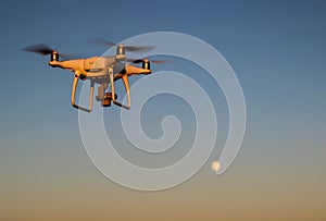 Quadrocopter against the blue sky takes off