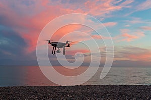 The quadrocopter in the air on the sunset background
