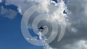 A quadrocopter aka drone is flying against the sky and landing on a dirt road