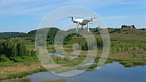 Quadrocopter with digital camera flying over lake. Izborsk, Russia