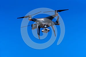 Quadrocopter with a professional camera flies in blue sky. Dron. photo