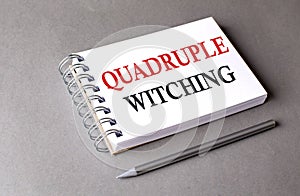 Quadruple Witching word on notebook on grey background