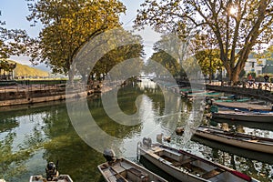 Quai Jules Philippe, a canal in the shade of plane trees, and boats on Lake Annecy, in Haute Savoie, France