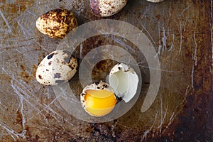 Quail egg broken on rustic table