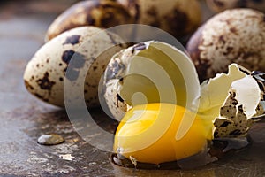 Quail egg broken on rustic table