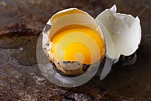 Quail egg broken on rustic table