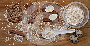 Quail eggs on a black bread and oat chips in a cup and cookie and a cinnamon stick