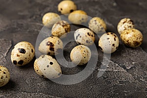 Quail eggs on black texture background