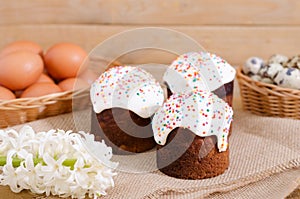 Quail eggs, chicken eggs in a basket, Easter cake on rustic wood