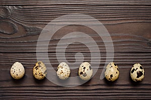 Quail eggs on dark wooden background. The view from the top. Copy spaÑe