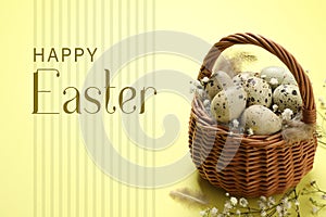 Quail eggs with flowers in wicker basket and text Happy Easter on background