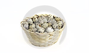 Quail eggs inside the basket on white background